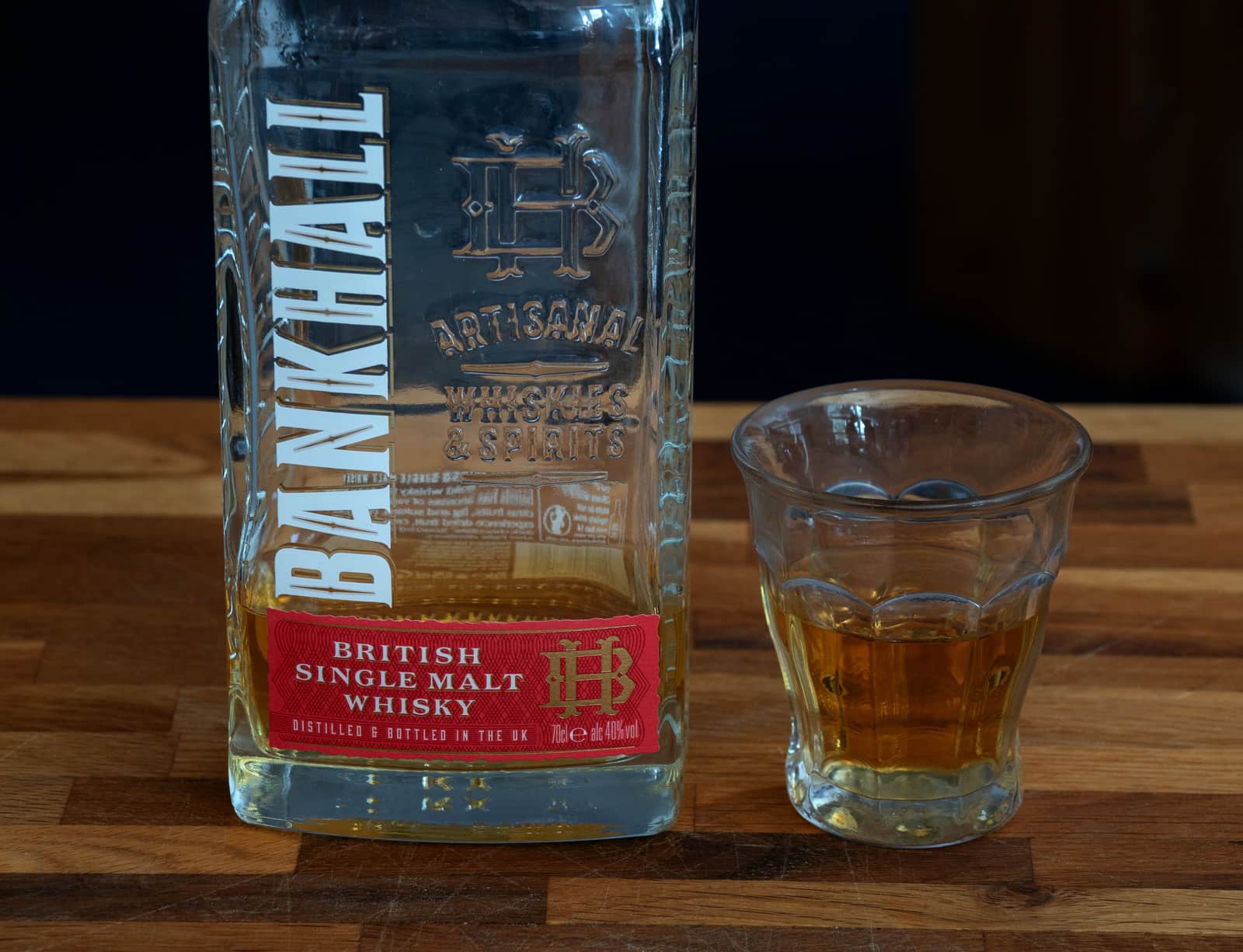 A single whiskey glass on a minimal table setting
