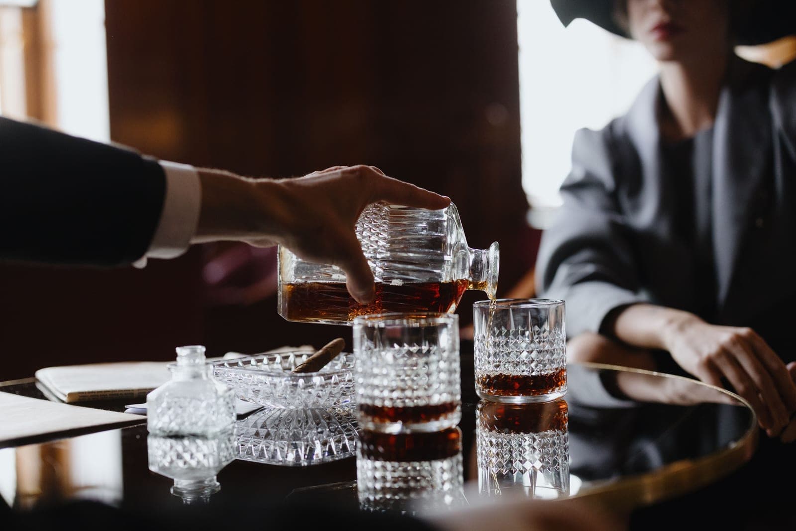 Whiskey being poured from a glass decanter