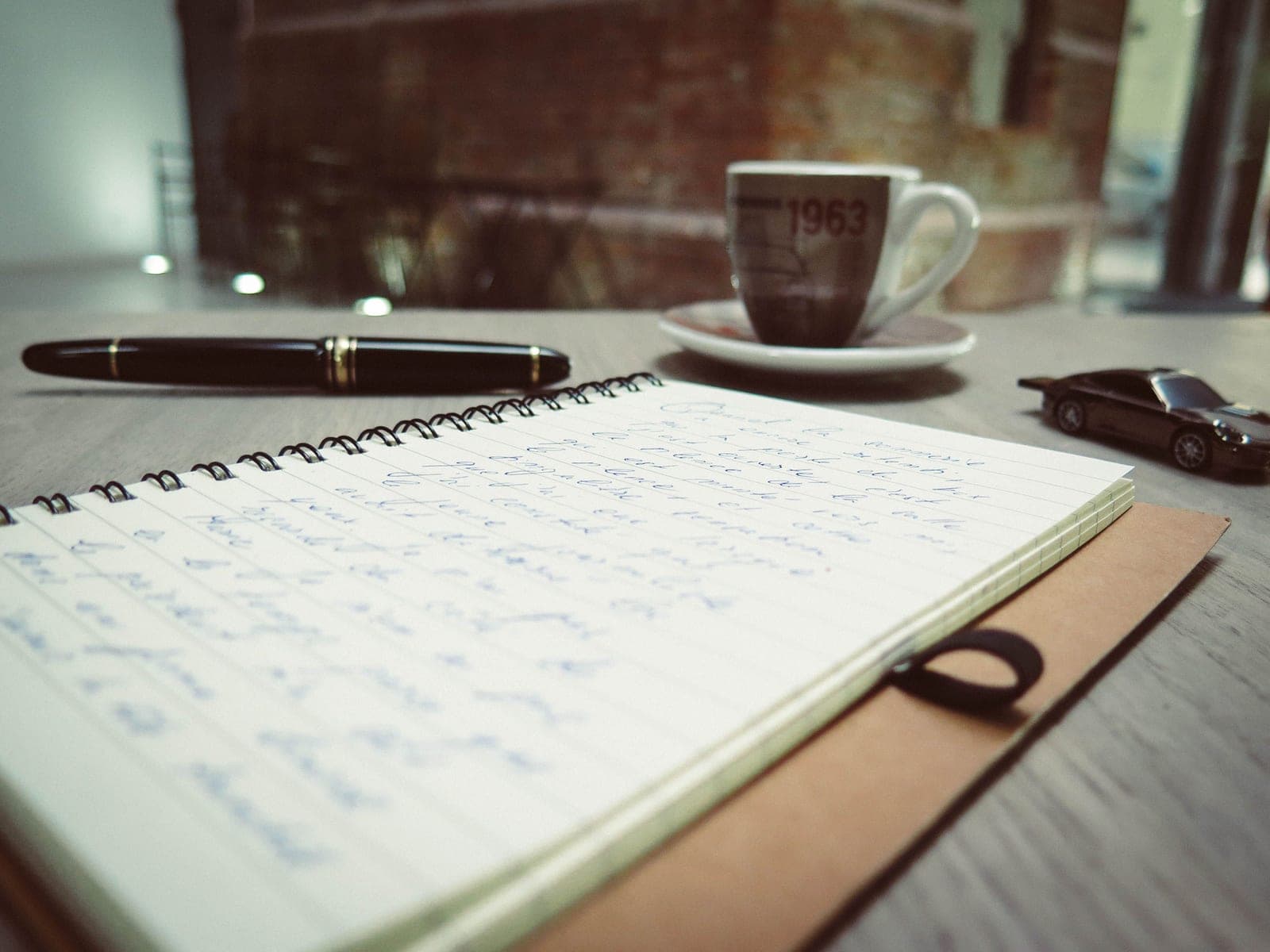 A writing desk with a notebook and small objects in warm light
