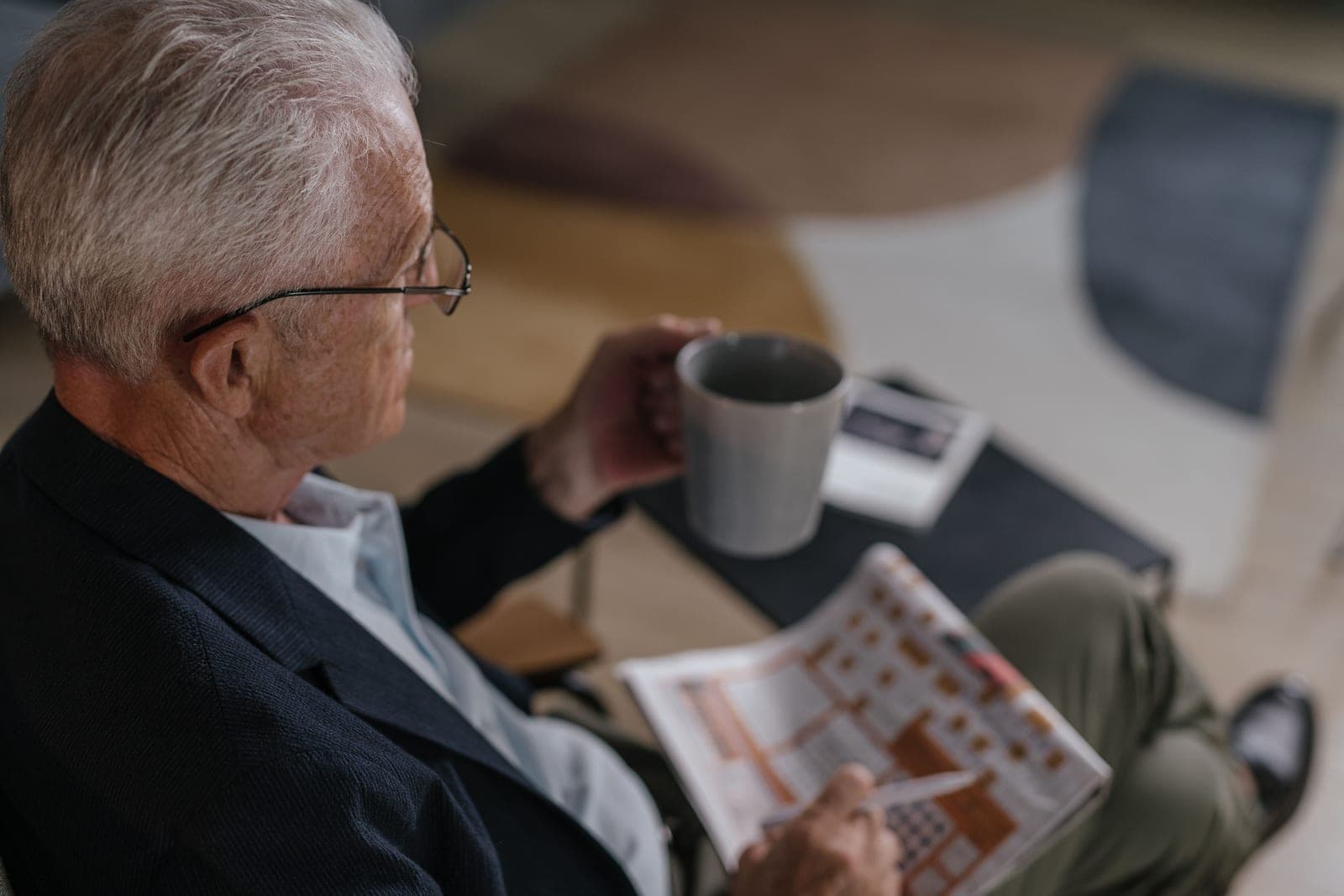 An older man relaxing in an armchair with a drink