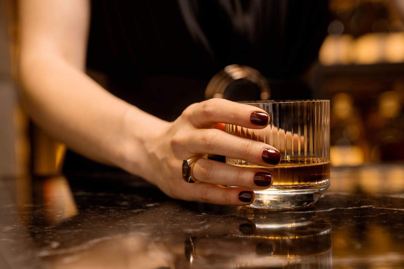 A woman holding a glass of whiskey