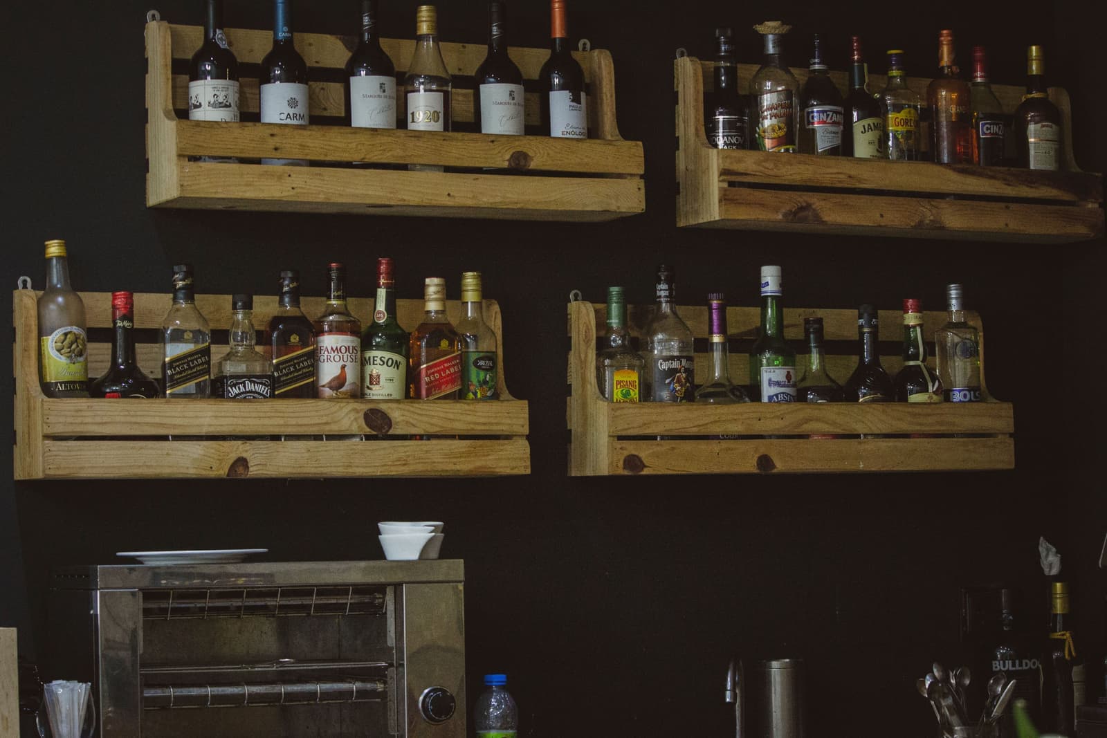 Whiskey bottles lined up on a wooden shelf