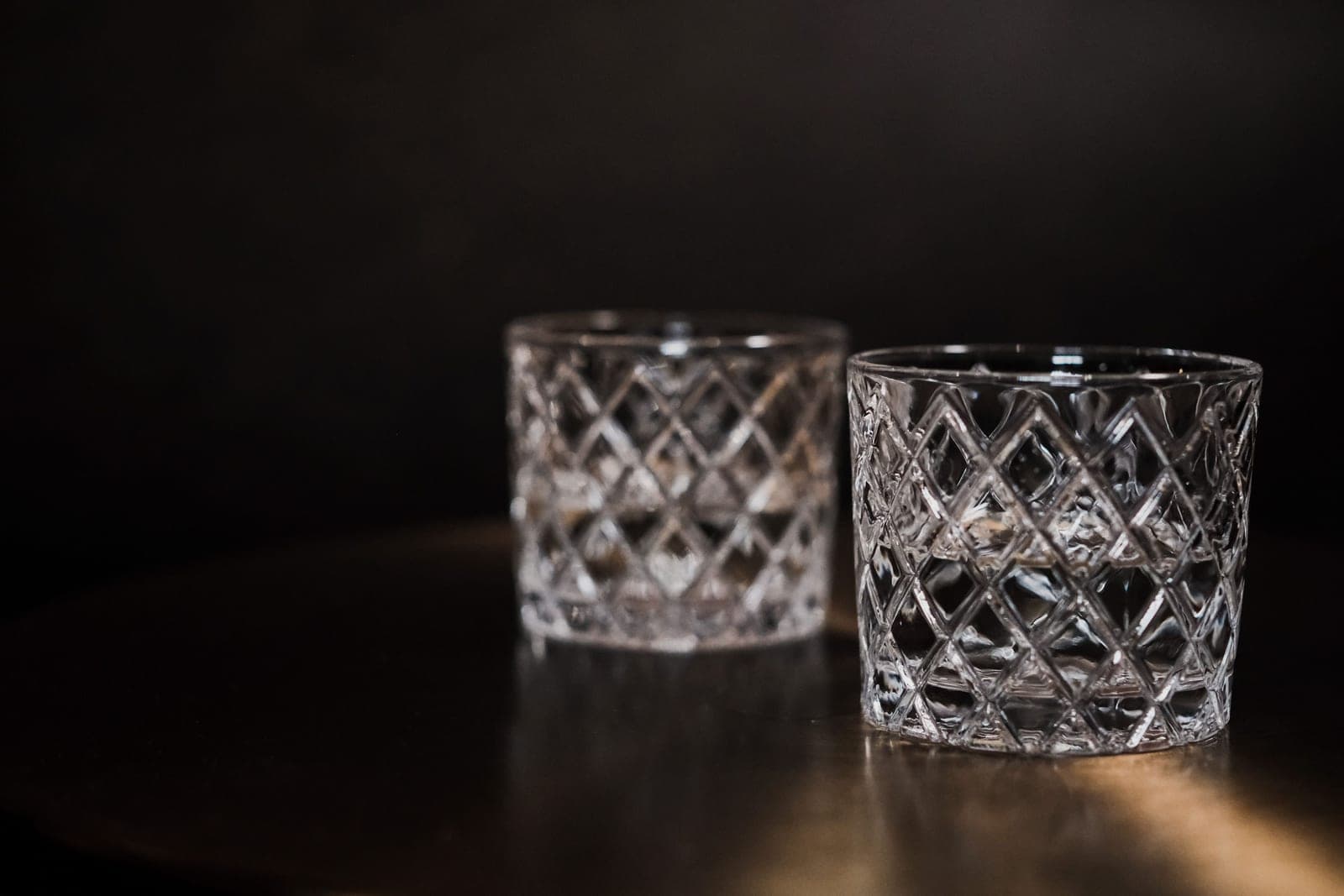 Empty whiskey glasses arranged on a bar counter